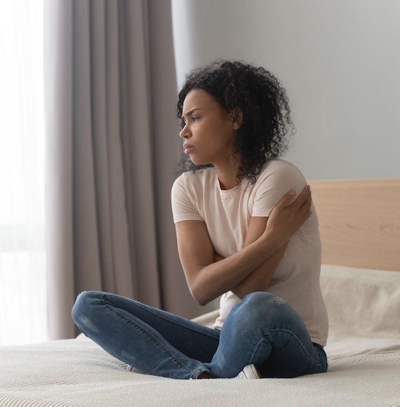 Upset,Sad,African,American,Woman,Sitting,In,Bed,Alone,,Hugging